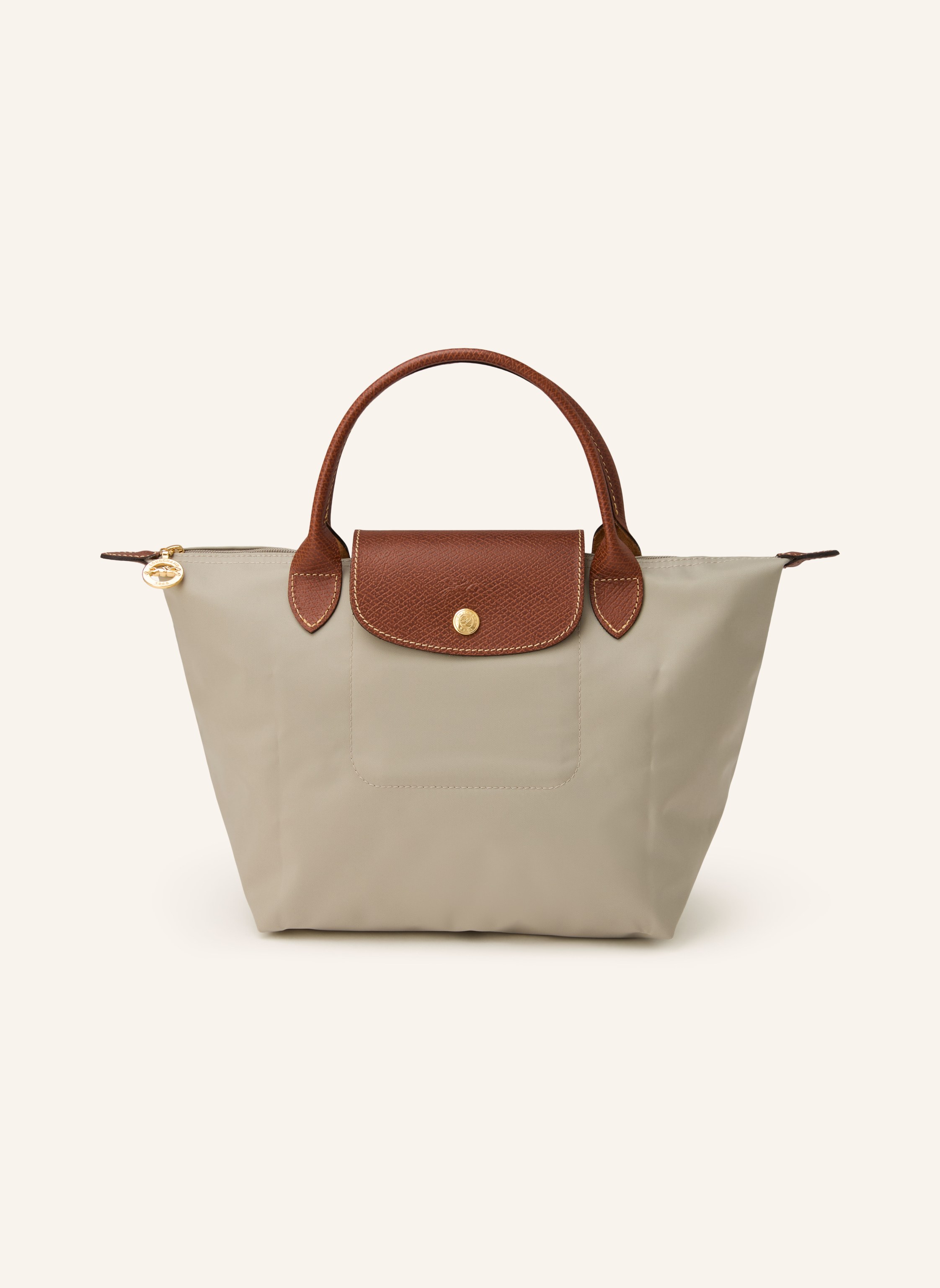 Longchamp Synthetik mit Lederdetails. Kurze Tragehenkel. Goldfarbene Metalldetails. Schließt mit einem Reißverschluss und Druckknopf. Faltbar in taupe / braun