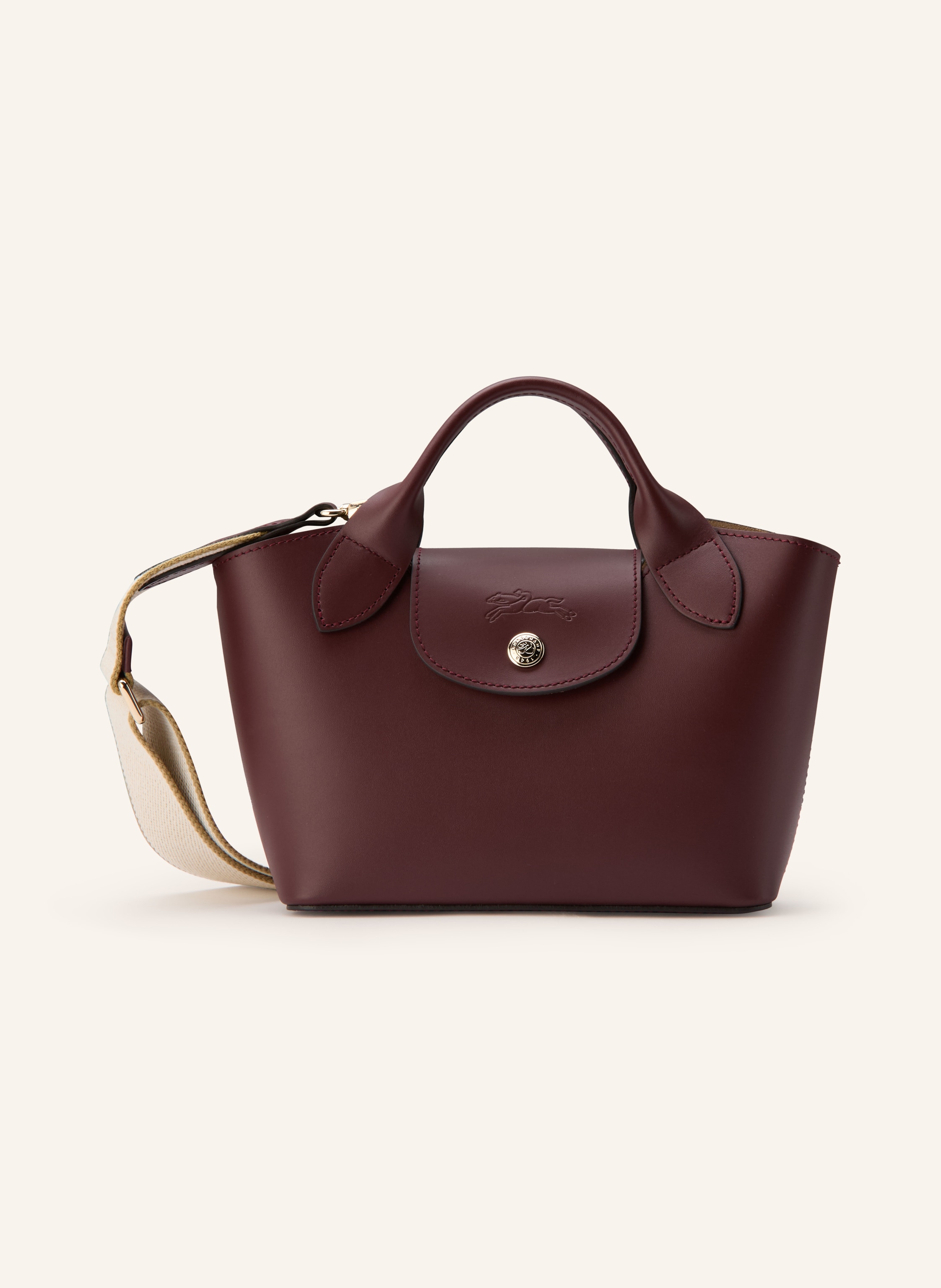 Longchamp Glattleder. Formstabile Silhouette. Schließt mit Druckknopfverschluss. Zwei Tragehenkel. Ein abnehmbarer, längenverstellbarer Schulterriemen. Innen ein Hauptfach. Ein Steckfach für Smartphone & Co. Ve in dunkelrot / gold / beige