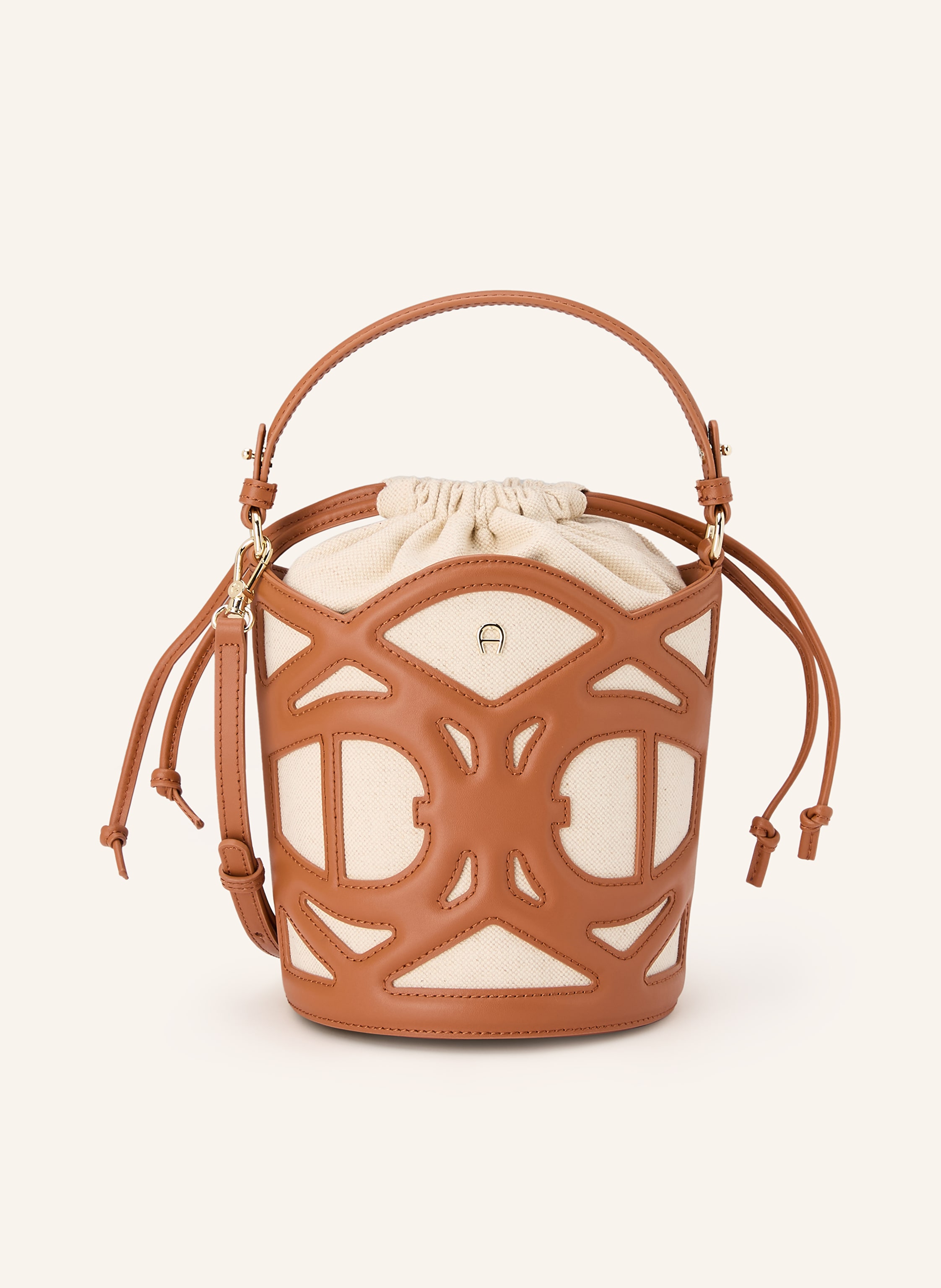 Aigner Innen ein Hauptfach. Abnehmbarer Schulterriemen. Ein Tragegriff. Längenverstellbarer Schulterriemen. Verstärkter Taschenboden. Durchzugsband. Label-Details. Canvas. Fein genarbtes Leder. Bicolor-Desig Small in creme / braun