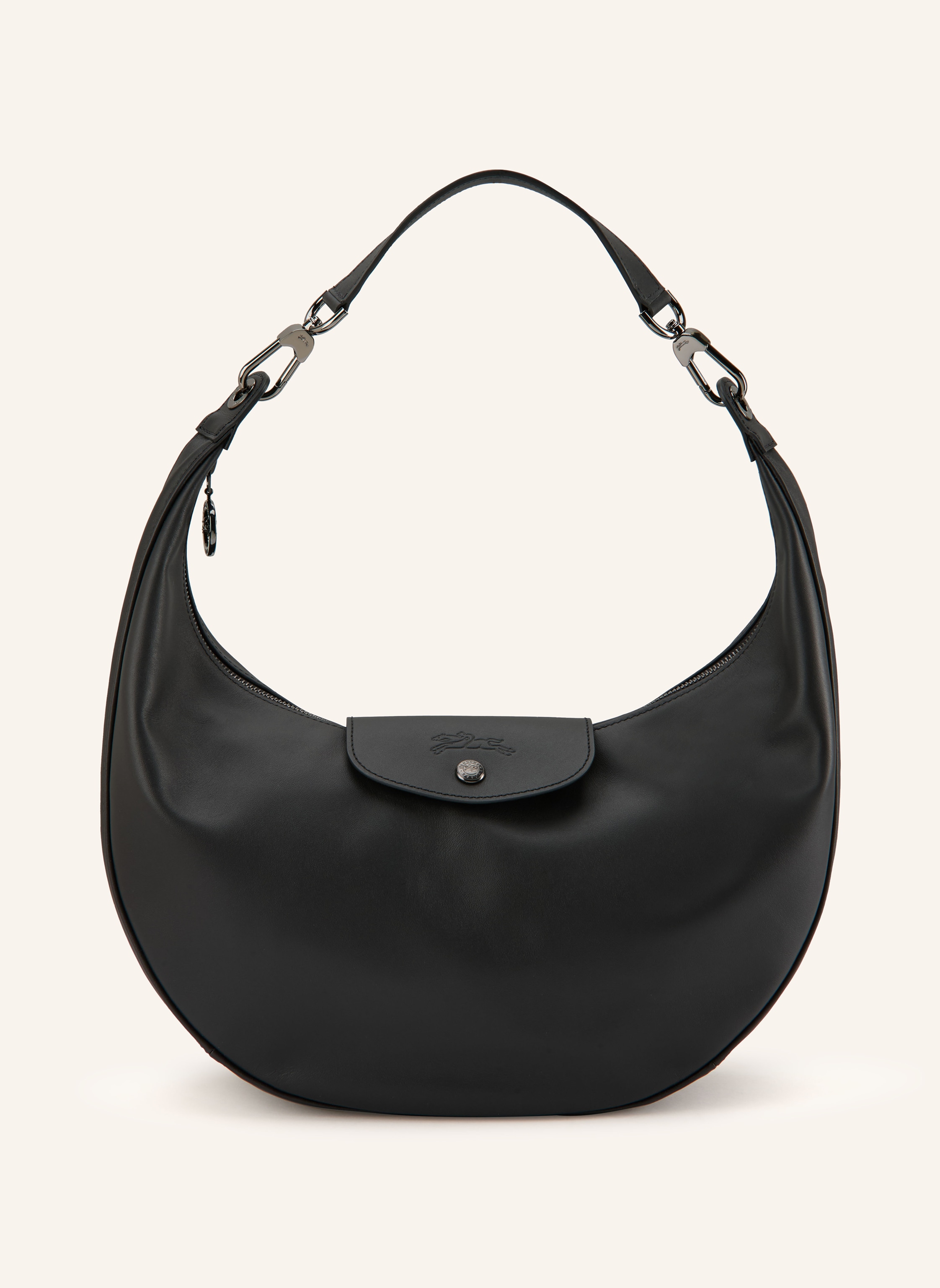 Longchamp Ein Innenfach mit Reißverschluss. Ein Steckfach. Abnehmbarer Schulterriemen. Ein Tragegriff. Verstärkter Taschenboden. Druckknopf. Karabinerverschluss. Reißverschluss. Label-Details. Fein genarbtes Le in schwarz / platin