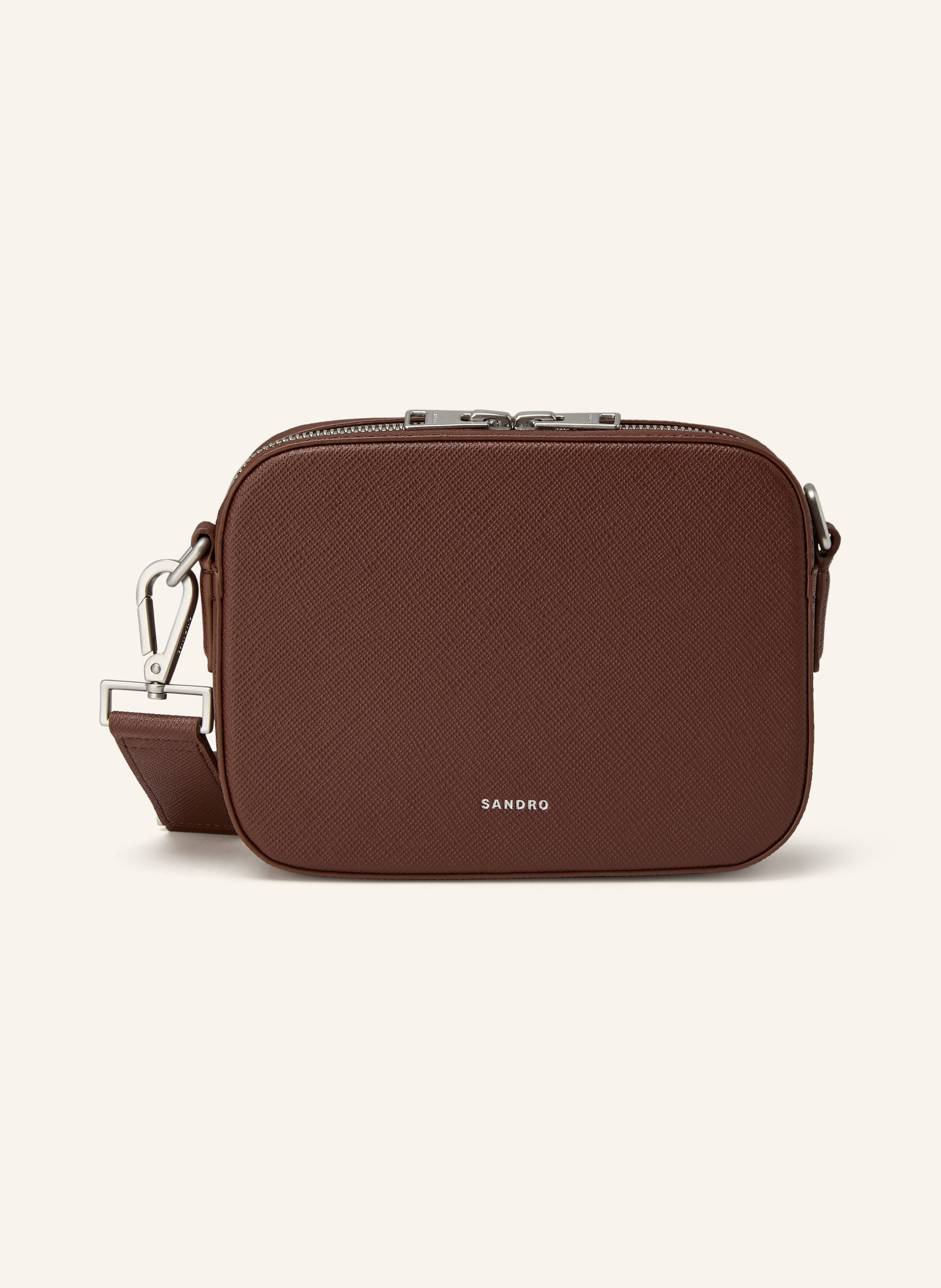 Sandro Saffiano-Leder. Silberfarbene Metalldetails. Schließt mit Reißverschluss. Abnehmbarer, längenverstellbarer Schulterriemen. Ein großes Hauptfach innen. Ein Steckfach für Smartphone & Co. Verstärkter Ta in cognac Saffiano-Leder