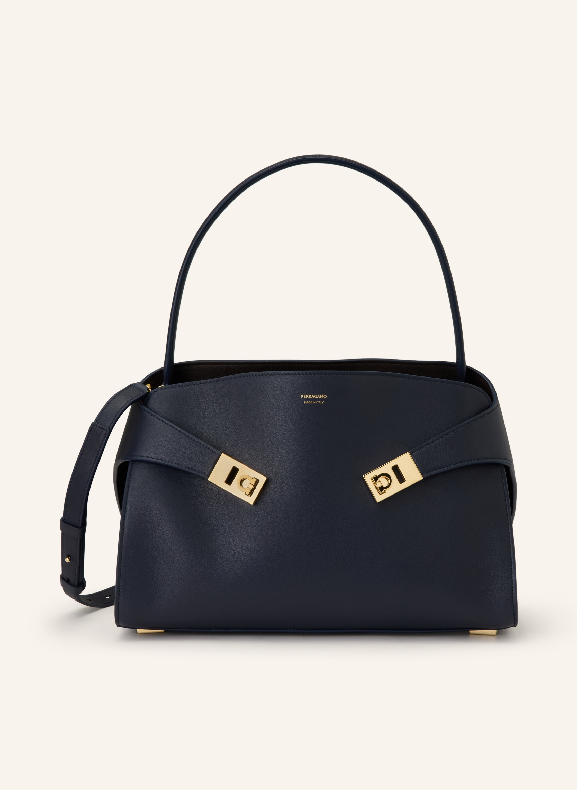Ferragamo Fein genarbtes Leder. Schließt mit Magnetverschlüssen. Ein Tragehenkel. Abnehmbarer, längenverstellbarer Schulterriemen. Zwei Hauptfächer innen. Ein Innenfach mit Reißverschluss. Zwei Kartenfächer. La in schwarz / gold