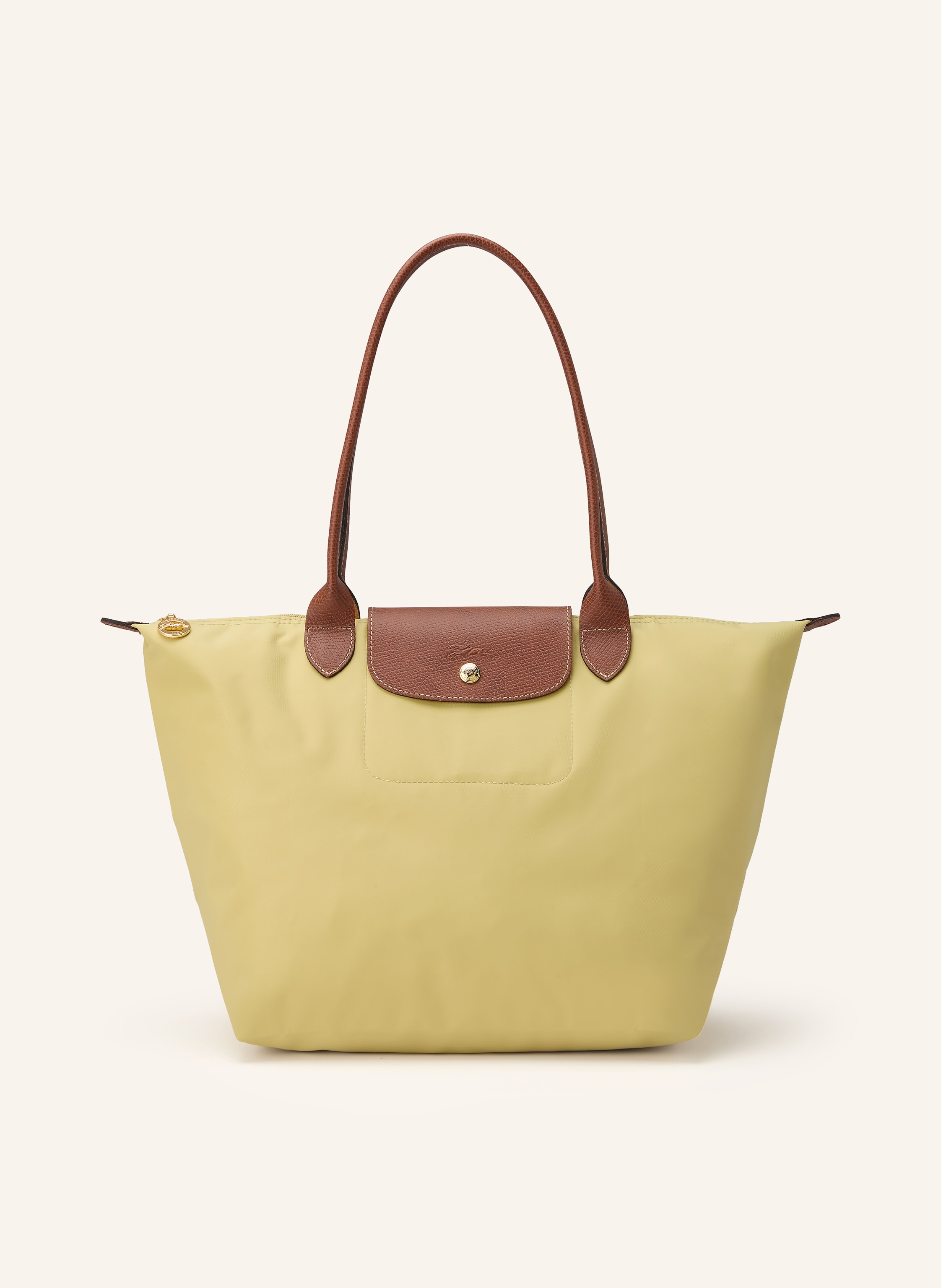 Longchamp Nylon und Leder. Tragehenkel. Schließt mit Reißverschluss. Lederbesatz mit Druckknopf und Logo-Prägung. Faltbar. Innentasche in hellgrün / braun