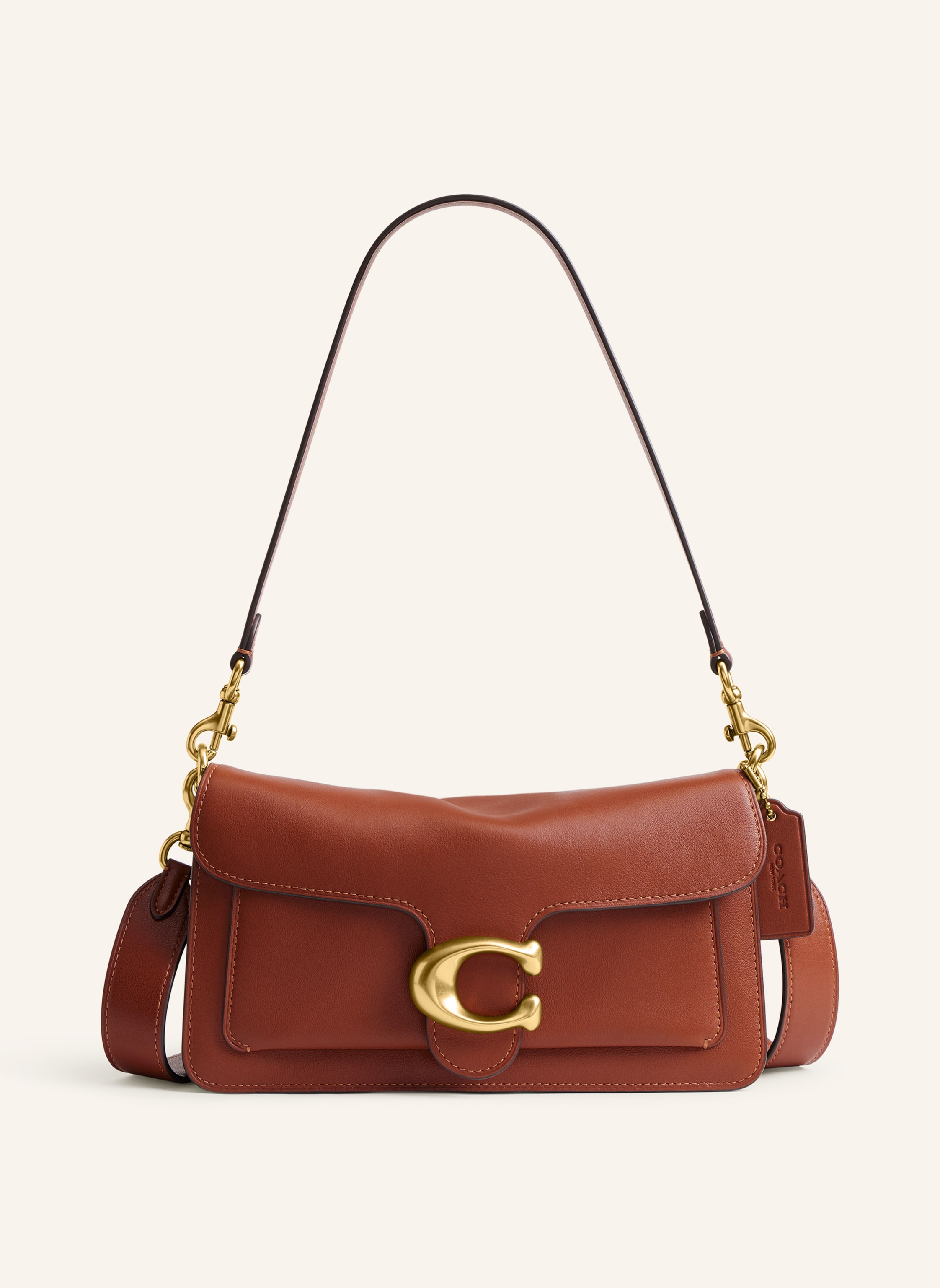 Coach Außenfach unter dem Überschlag. Abnehmbarer Schulterriemen. Ein Tragegriff. Stellfüßchen. Verstärkter Taschenboden. Druckknopf. Innen zwei Hauptfächer. Label-Detail. Glattleder. Unifarben in braun / gold