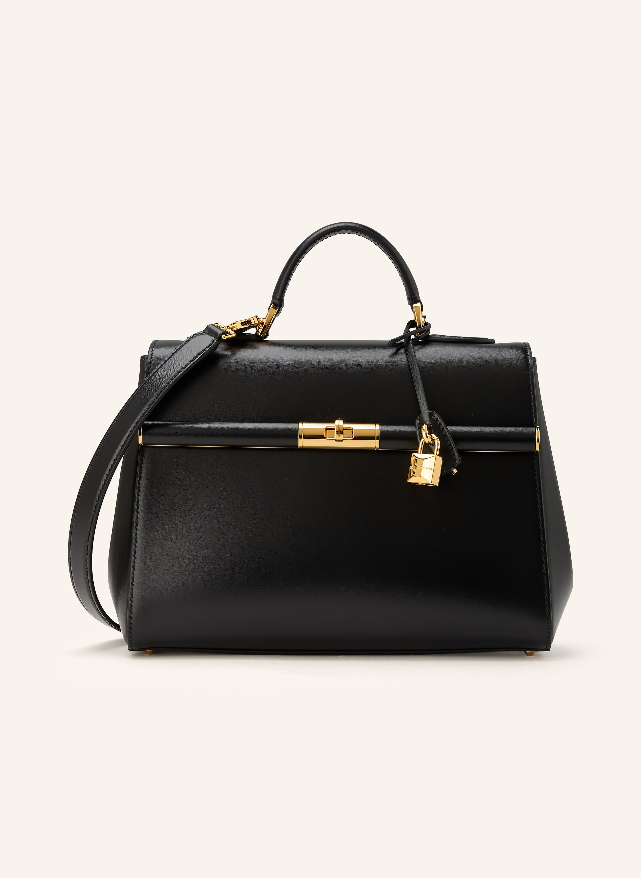 Dolce & Gabbana Ein Innenfach mit Reißverschluss. Ein Steckfach. Abnehmbarer Schulterriemen. Ein Tragegriff. Längenverstellbarer Schulterriemen. Stellfüßchen. Verstärkter Taschenboden. Drehverschluss. Innen ein Haupt in schwarz / gold