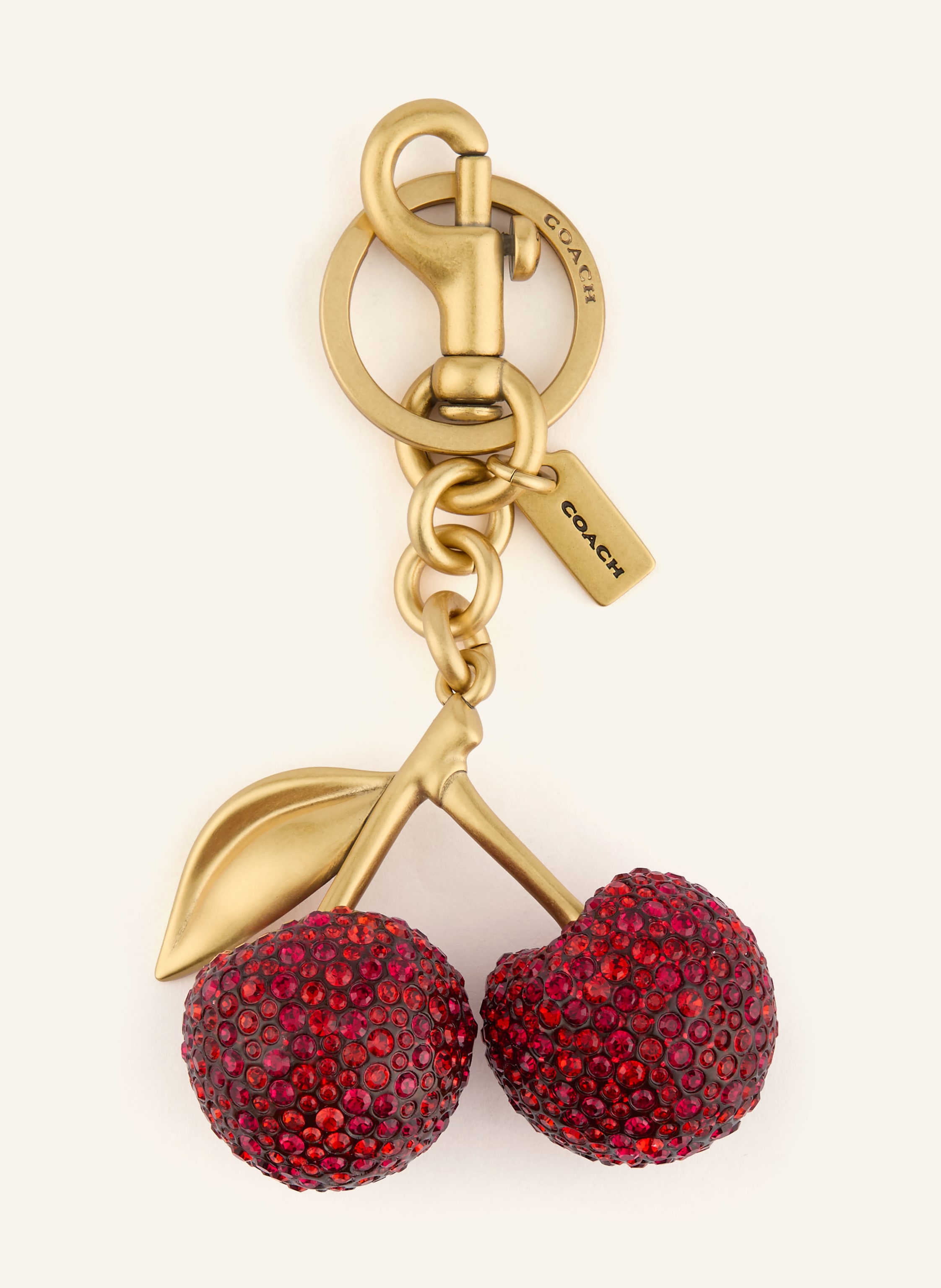 Coach Karabiner. Label-Detail. Metall. Goldfarbene Metalldetails. Unifarben. Schmucksteinbesatz in rot / gold