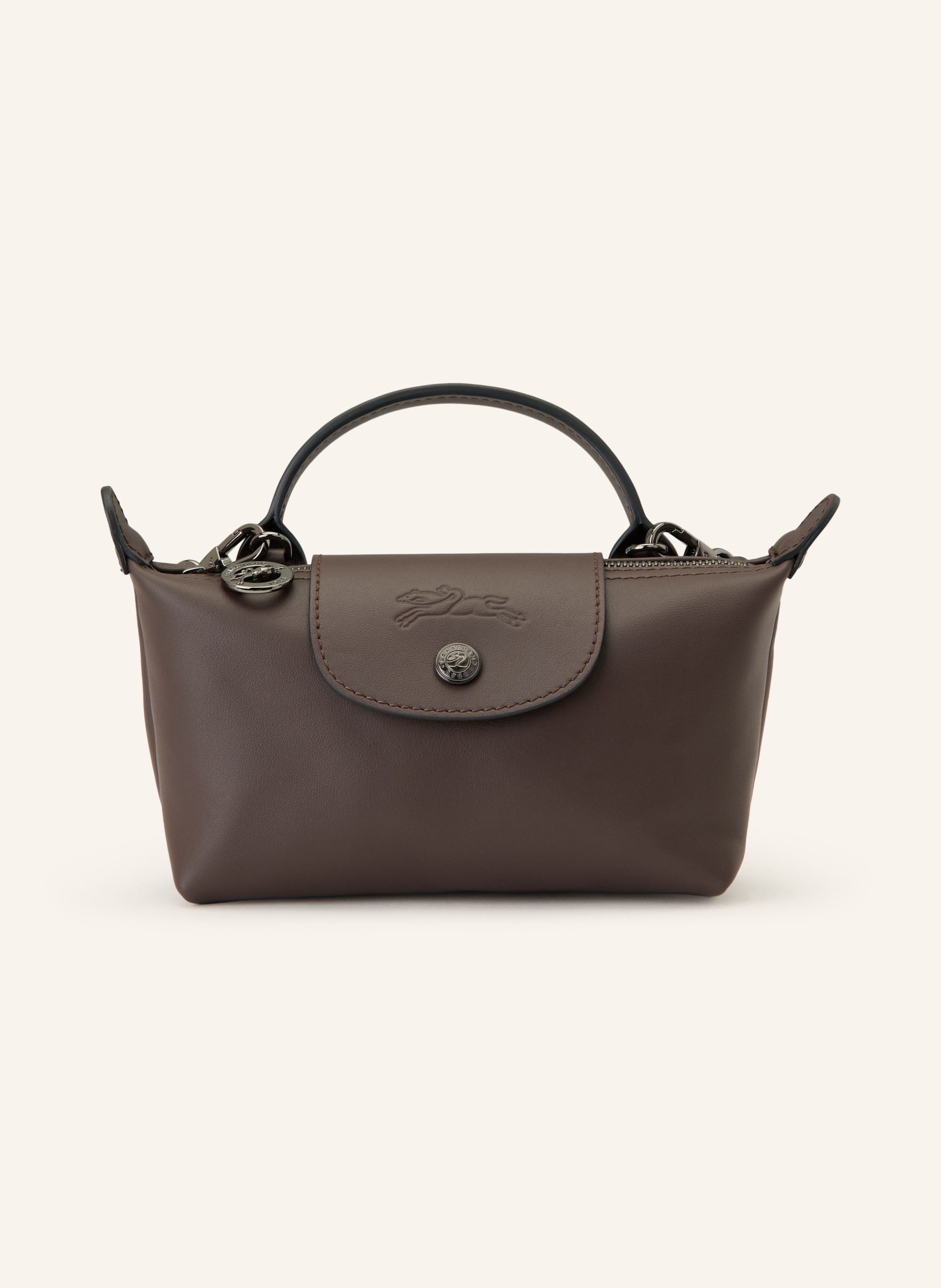 Longchamp Glattleder. Schließt mit Druckknopf und Reißverschluss. Ein Tragehenkel. Abnehmbarer, längenverstellbarer Schulterriemen. Ein Hauptfach innen. Ein kleines Kartensteckfach. Label-Prägung auf der Rückse in dunkelbraun