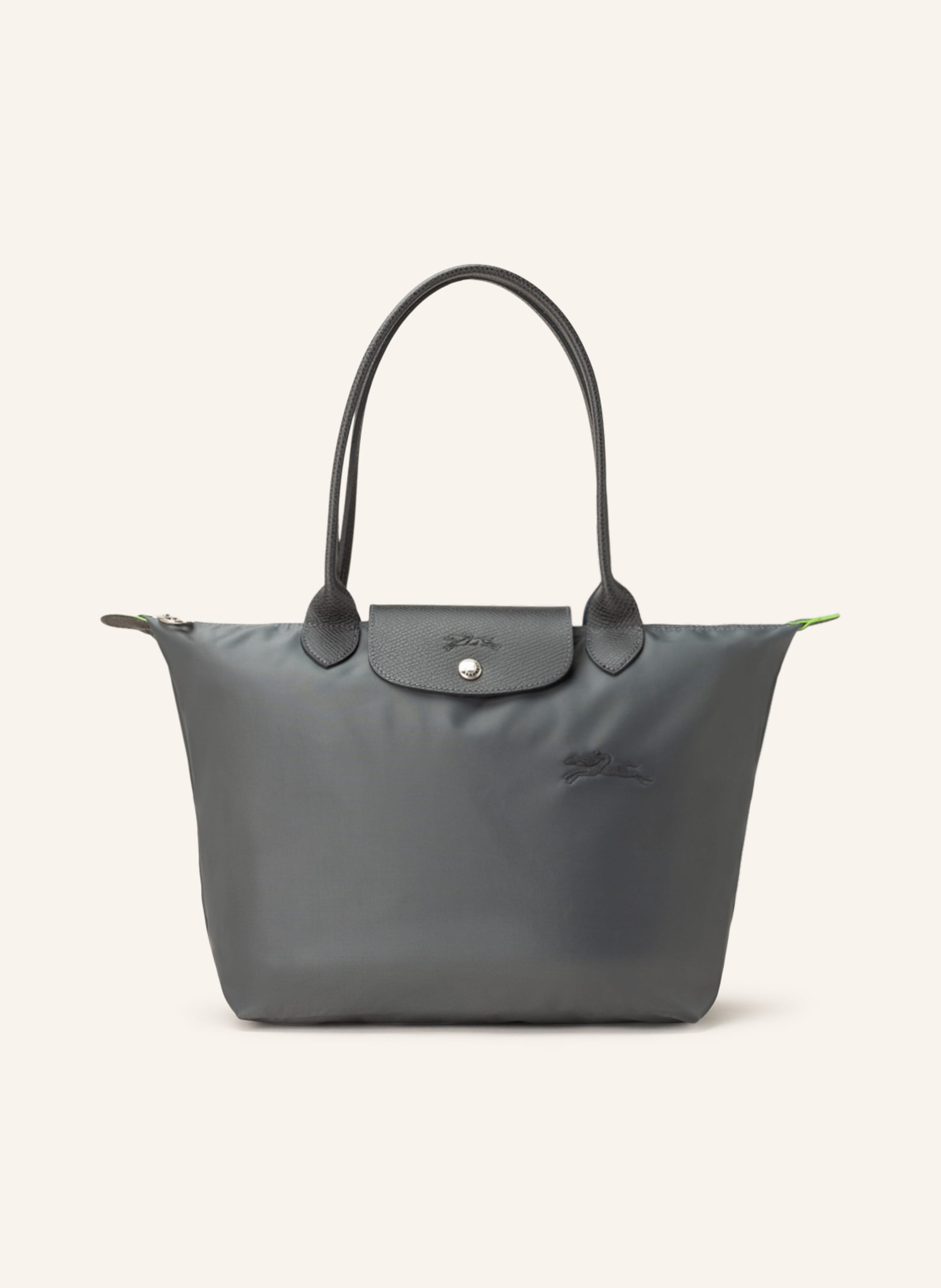 Longchamp Textil mit Lederdetails. Reptilienoptik. Silberfarbene Metalldetails. Schließt mit einem Reißverschluss. Zwei Trageriemen. Überschlag mit Druckknopf zum Falten. Innen ein Hauptfach. Ein Steckfach für in dunkelgrau