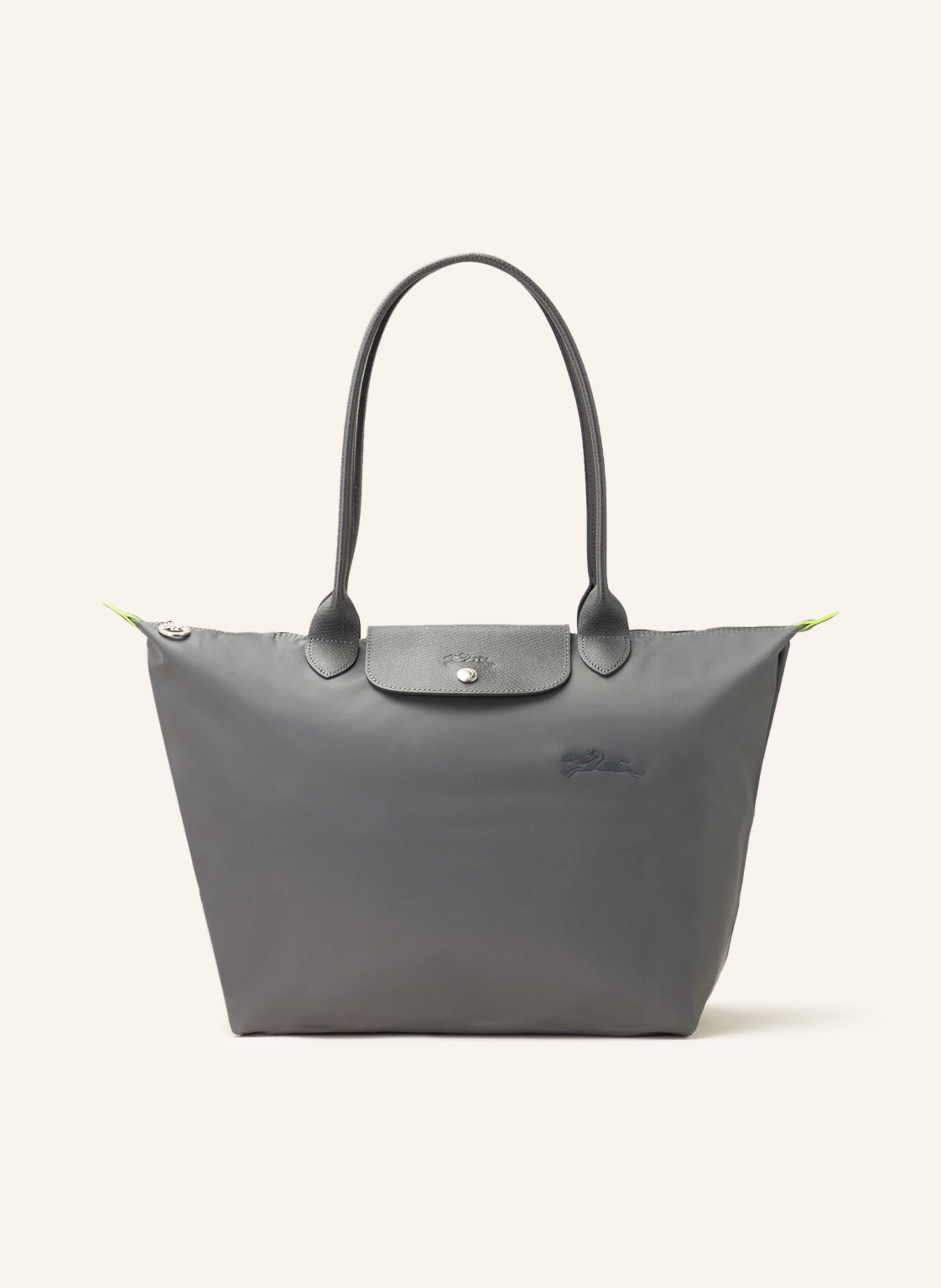 Longchamp Textil mit Lederdetails. Reptilienoptik. Silberfarbene Metalldetails. Schließt mit einem Reißverschluss. Zwei Trageriemen. Überschlag mit Druckknopf zum Falten. Innen ein Hauptfach. Ein Steckfach für in dunkelgrau