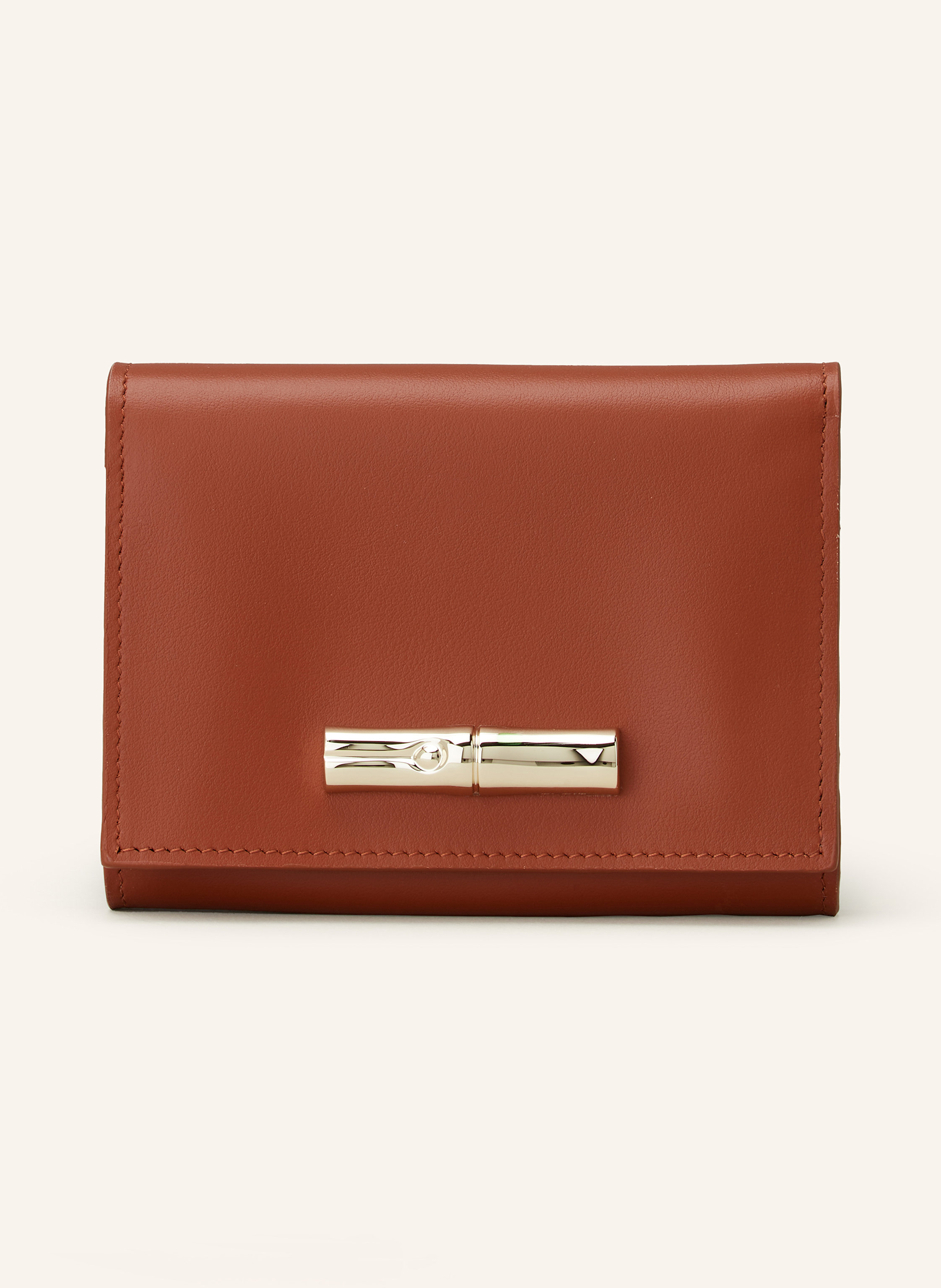 Longchamp Glattleder. Schließt mit Druckknopf. Münzfach mit Reißverschluss. Geldscheinfach. Neun Kartensteckfächer. Zwei Steckfächer. Goldfarbene Hardware in braun