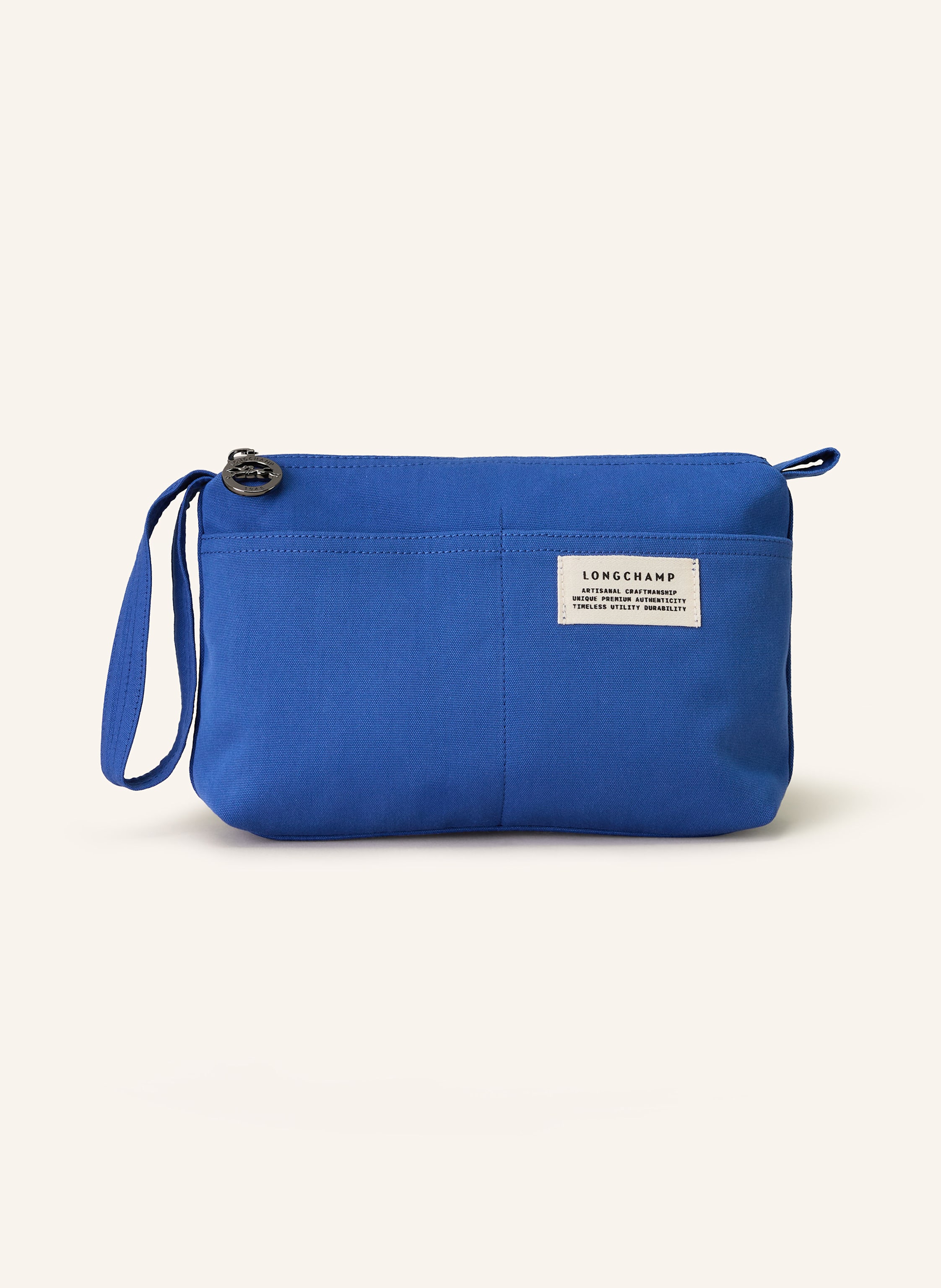 Longchamp Canvas. Schließt mit Reißverschluss. Ein Tragegriff. Außenfächer auf der Vorderseite. Innen ein Hauptfach. Steckfach für Smartphone & Co. Label-Patch in blau