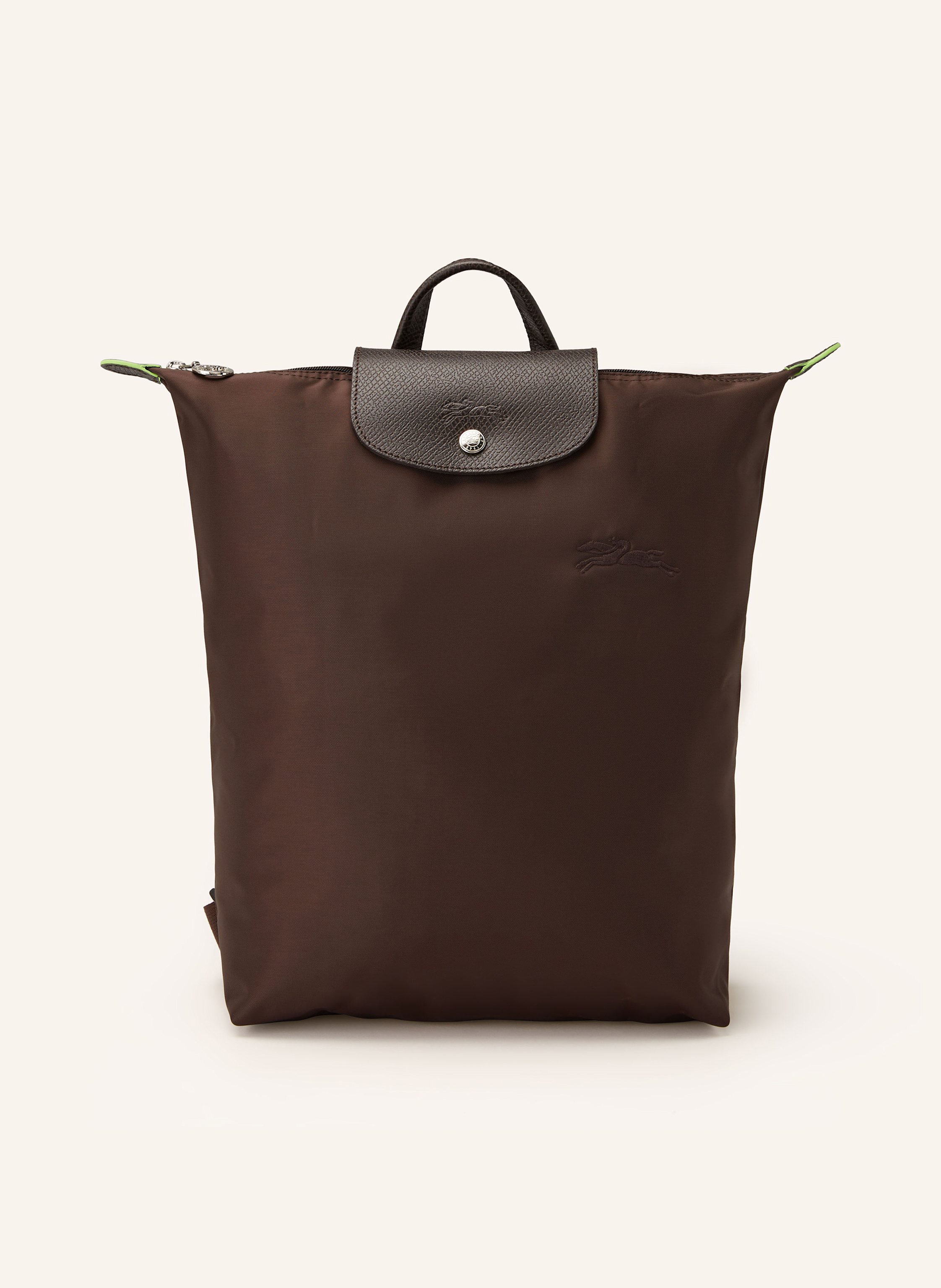 Longchamp Textil mit Lederdetails. Silberfarbene Metalldetails. Schließt mit einem Reißverschluss und Druckknopf. Längenverstellbare Schulterriemen. Tragegriff. Steckfach innen. Label-Details. Dank zusätzlichem in dunkelbraun