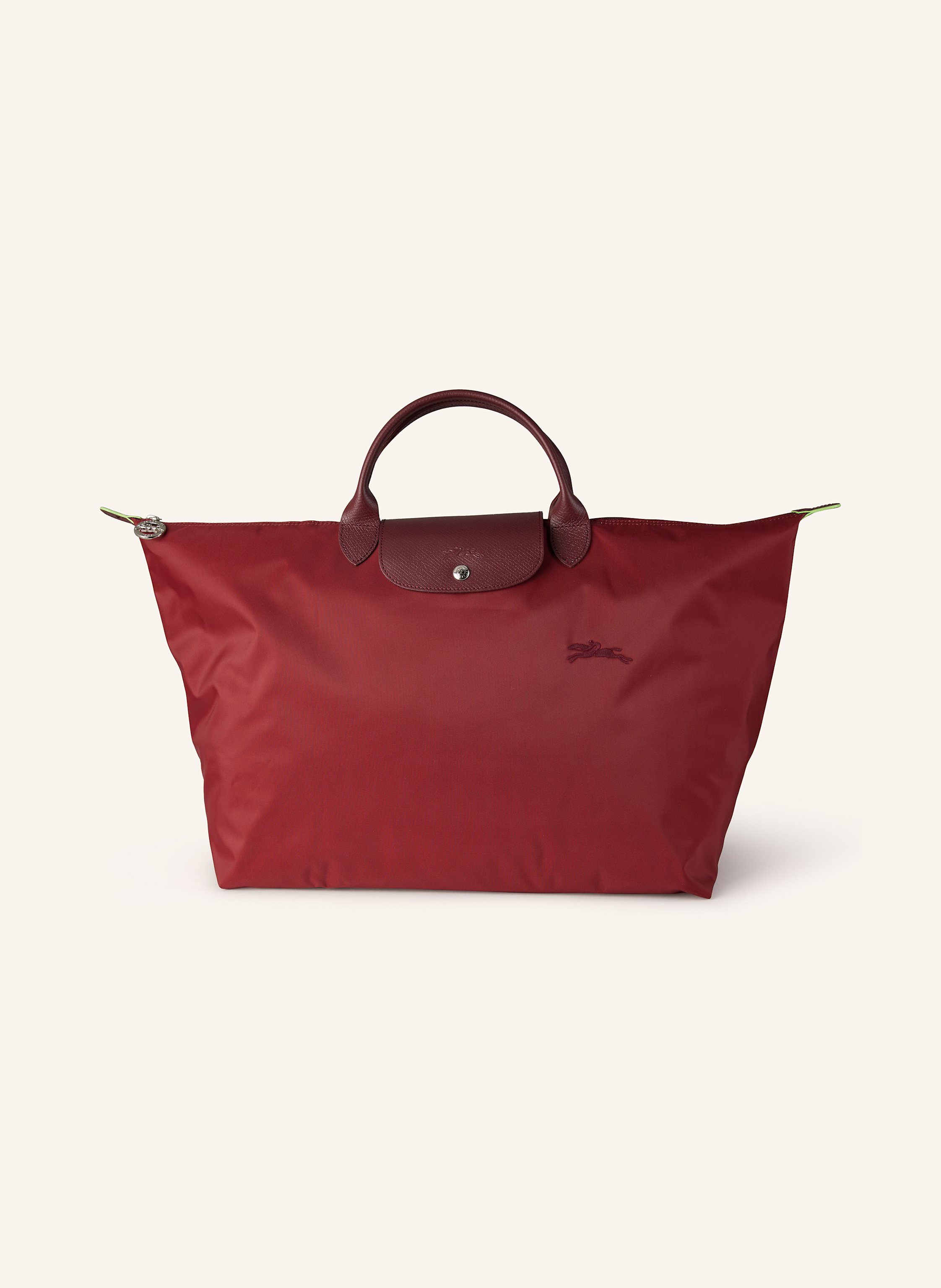 Longchamp Textil mit Lederdetails. Silberfarbene Metalldetails. Schließt mit einem Reißverschluss. Zwei Trageriemen. Überschlag mit Druckknopf zum Falten. Innen ein Hauptfach. Ein Steckfach für Smartphone & Co. Large in dunkelrot