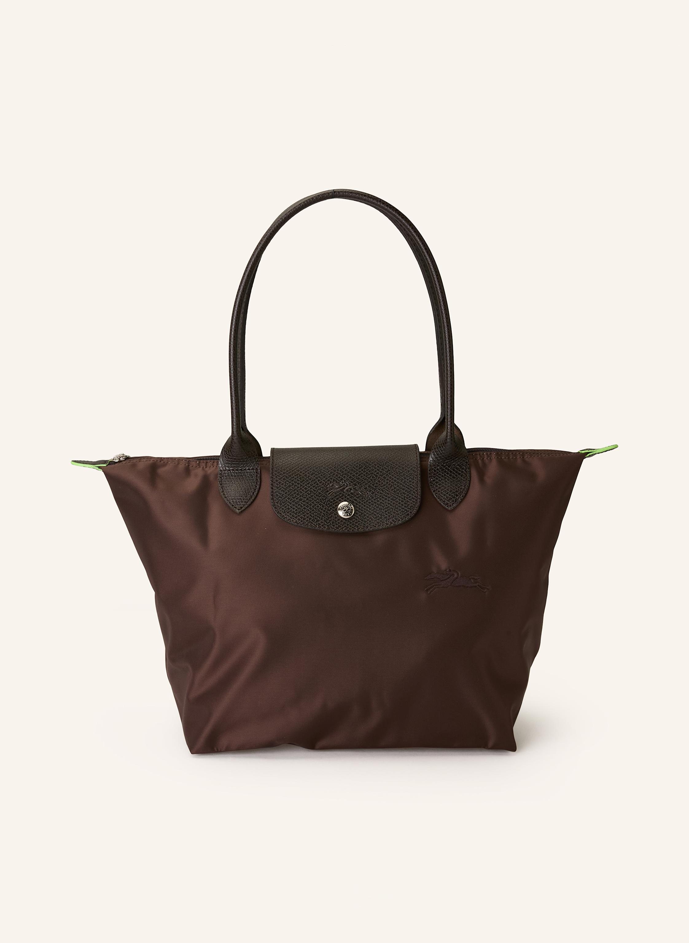 Longchamp Textil mit Lederdetails. Reptilienoptik. Silberfarbene Metalldetails. Schließt mit einem Reißverschluss. Zwei Trageriemen. Überschlag mit Druckknopf zum Falten. Innen ein Hauptfach. Ein Steckfach für in dunkelbraun