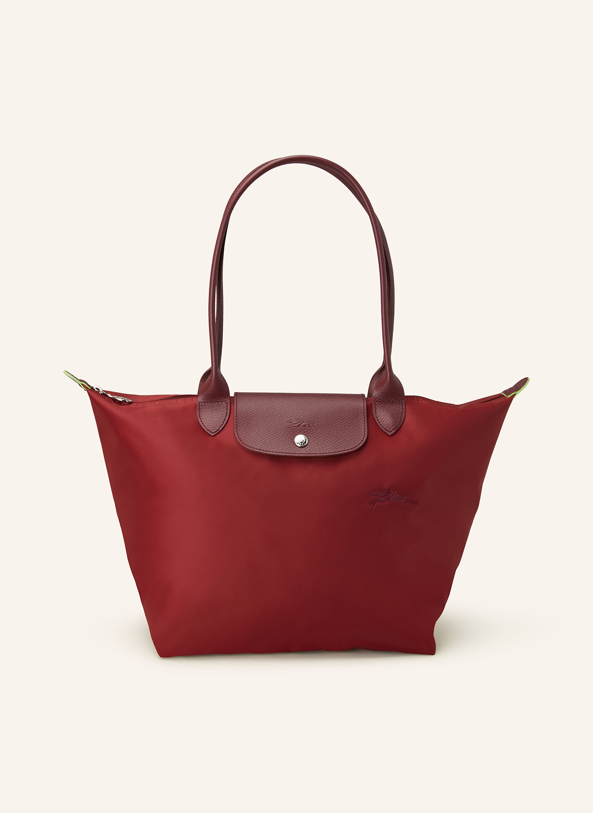 Longchamp Textil mit Lederdetails. Reptilienoptik. Silberfarbene Metalldetails. Schließt mit einem Reißverschluss. Zwei Trageriemen. Überschlag mit Druckknopf zum Falten. Innen ein Hauptfach. Ein Steckfach für in dunkelrot