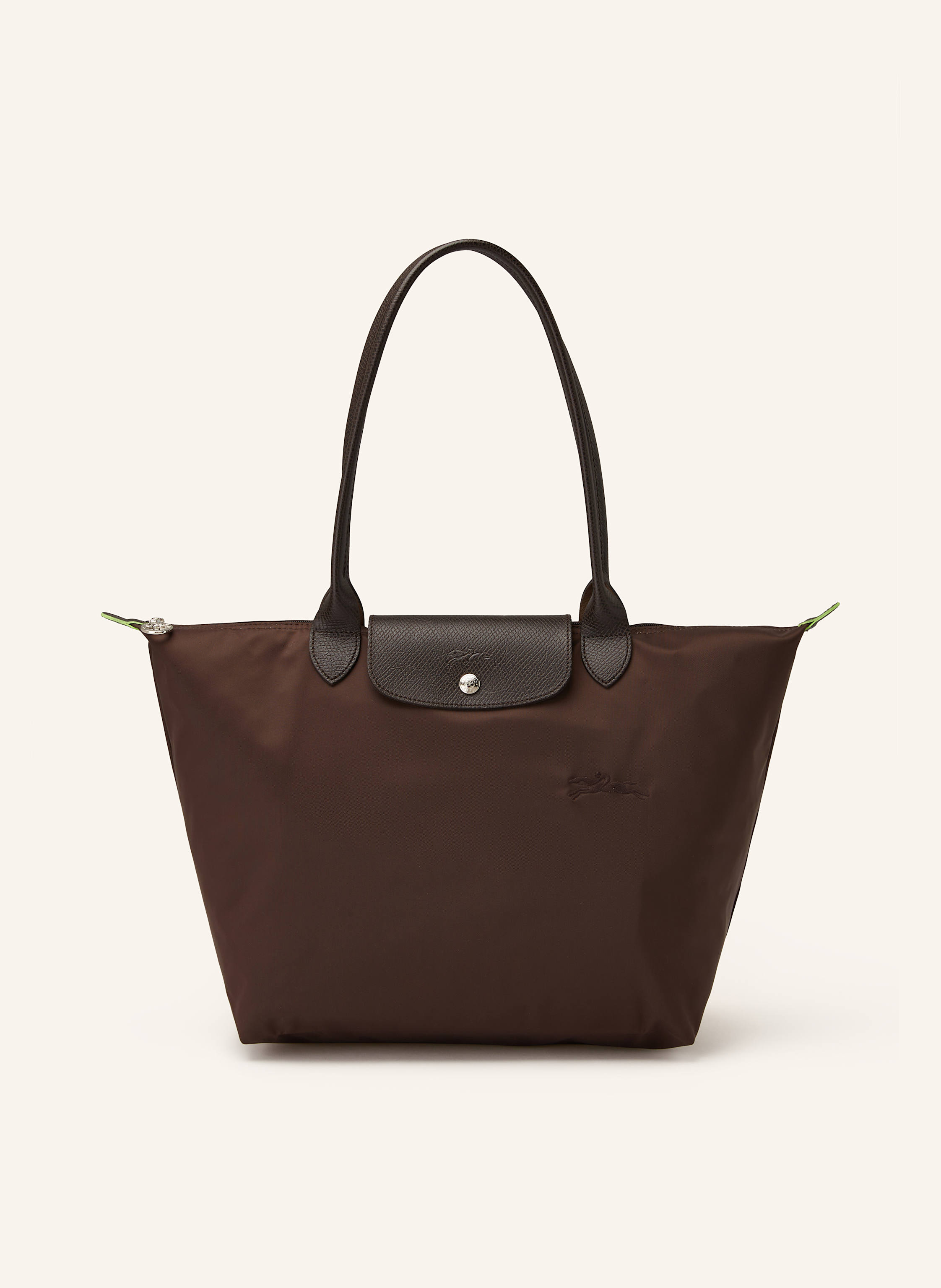 Longchamp Textil mit Lederdetails. Reptilienoptik. Silberfarbene Metalldetails. Schließt mit einem Reißverschluss. Zwei Trageriemen. Überschlag mit Druckknopf zum Falten. Innen ein Hauptfach. Ein Steckfach für in dunkelbraun