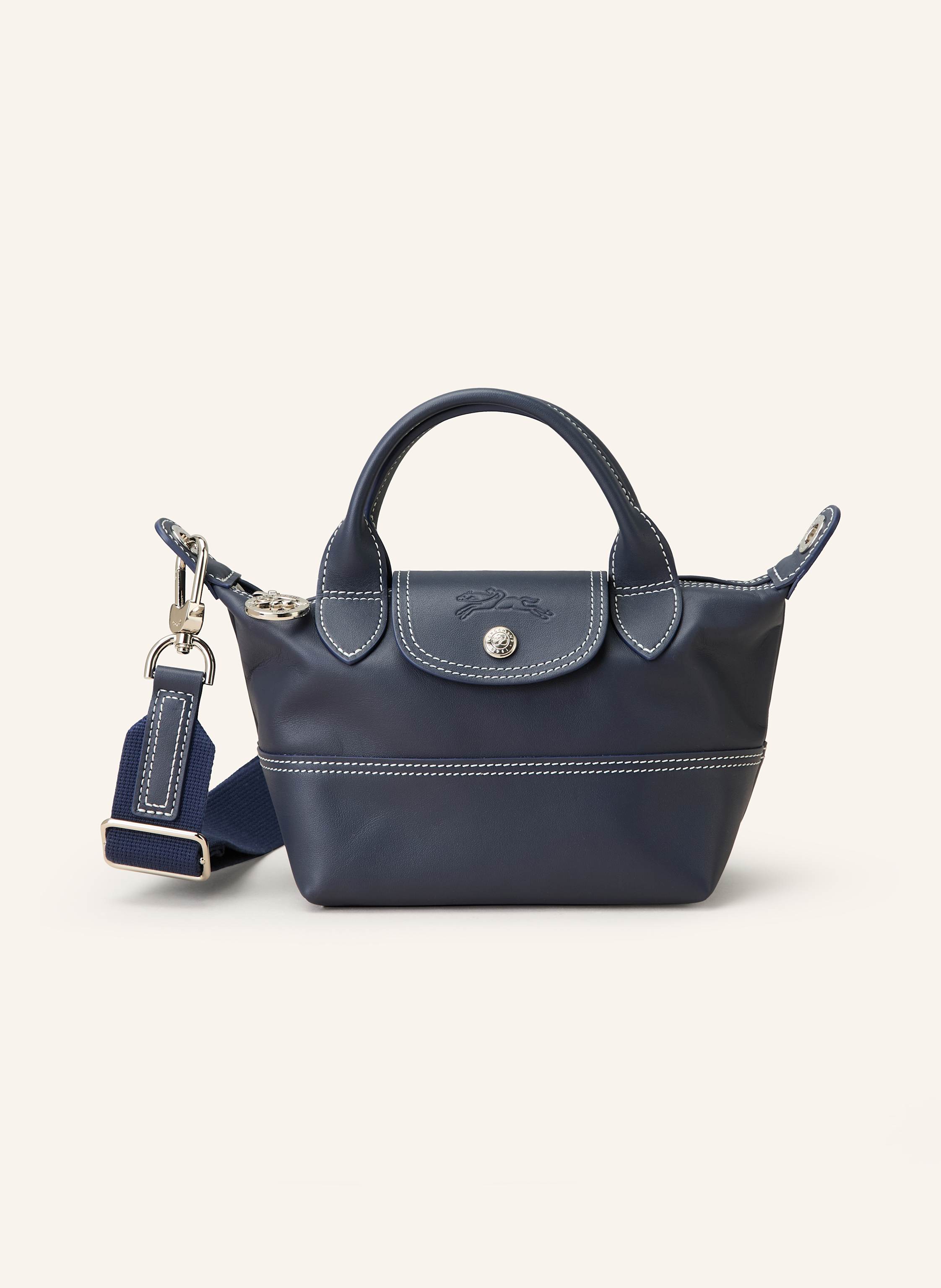 Longchamp Fein genarbtes Leder. Ziernähte. Schließt mit Reißverschluss und Druckknopf. Zwei Tragegriffe. Abnehmbarer, längenverstellbarer Schulterriemen. Innen ein Hauptfach. Innenfach mit Reißverschluss. Ein S in dunkelblau
