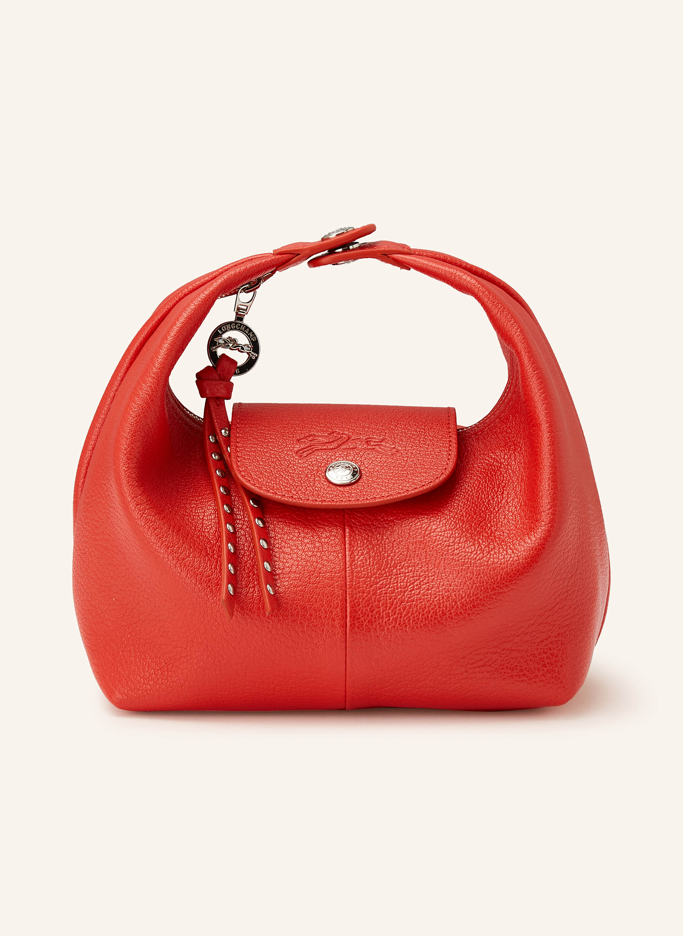 Longchamp Genarbtes Leder. Schließt mit Reißverschluss und Druckknopf. Ein Tragegriff mit Druckknopf. Innen ein Hauptfach. Innenfach mit Reißverschluss. Ein Kartenfach. Logo-Prägung in rot