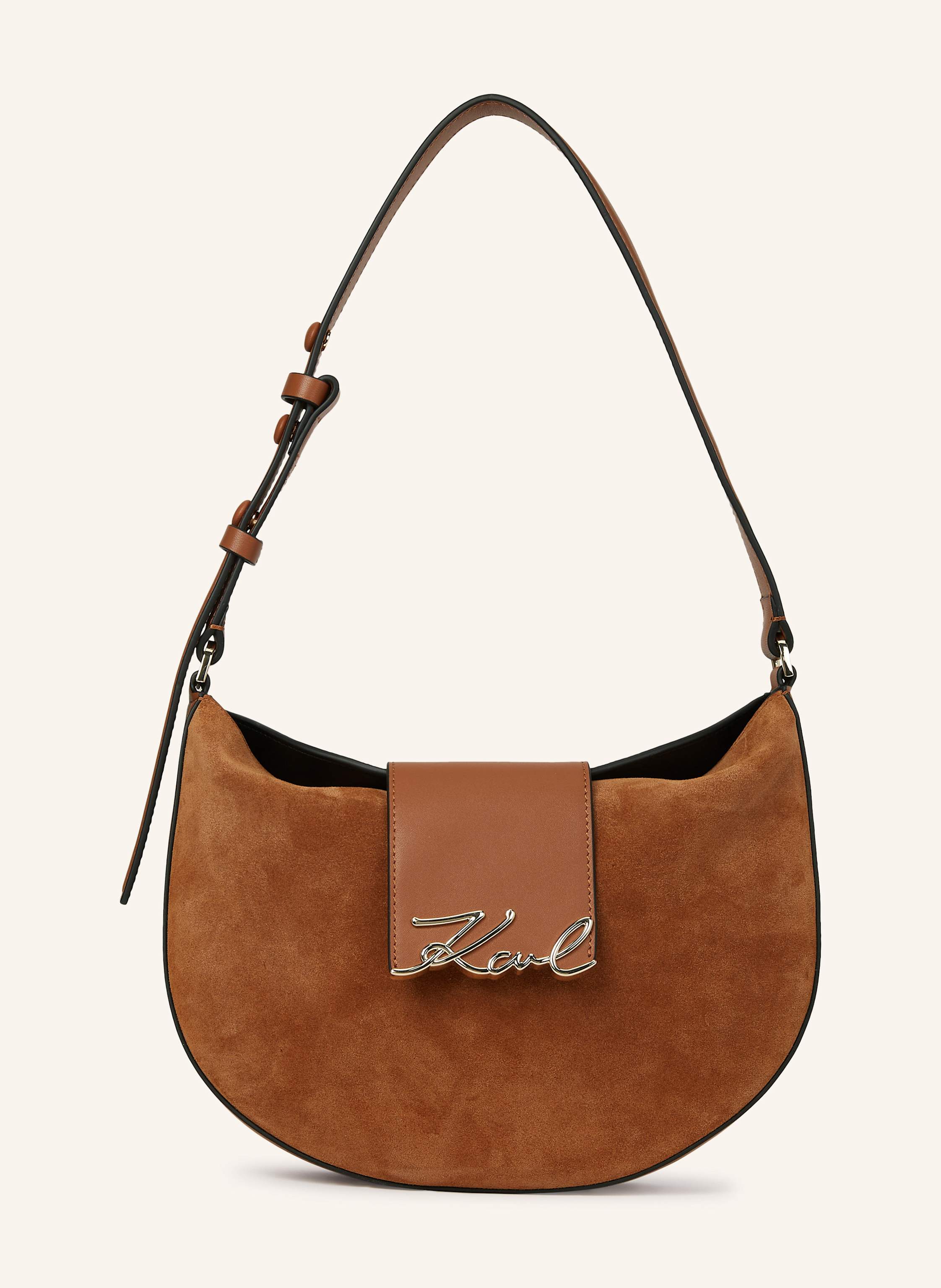 Karl Lagerfeld Eine weiche Wildleder-Umhängetasche mit elegantem Laschenverschluss, die mühelose Eleganz und bequemen Komfort bietet. Die filigrane Metallelement mit Karl Signature verleiht diesem zeitlosen Stück ei in braun