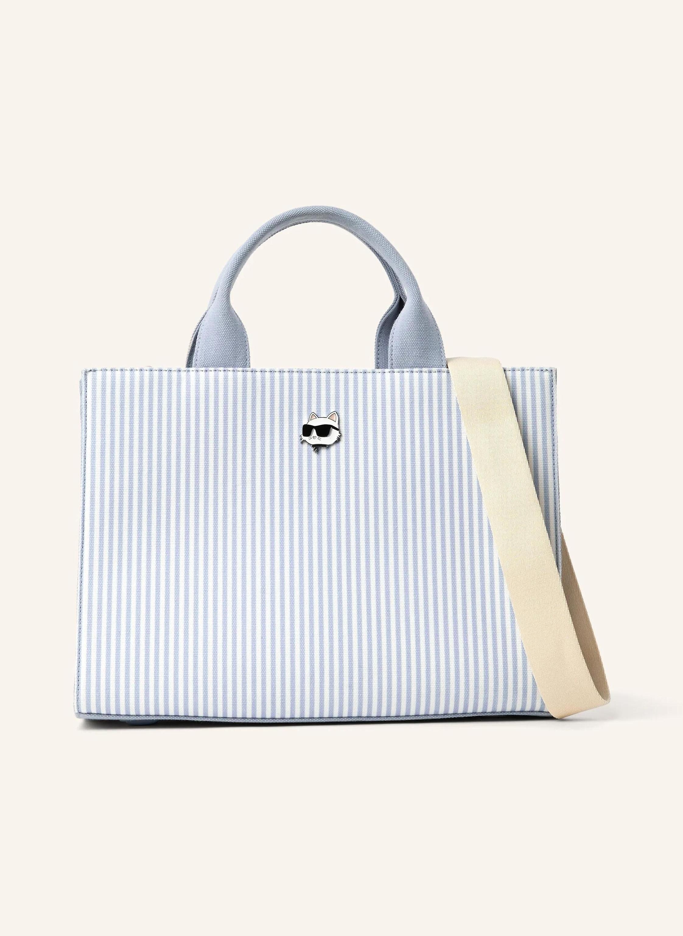 Karl Lagerfeld A structured tote with a spacious square silhouette that moves with ease. Striped with subtle charm, it features twin handles and a versatile detachable strap for effortless style. Spacious and struct in blau
