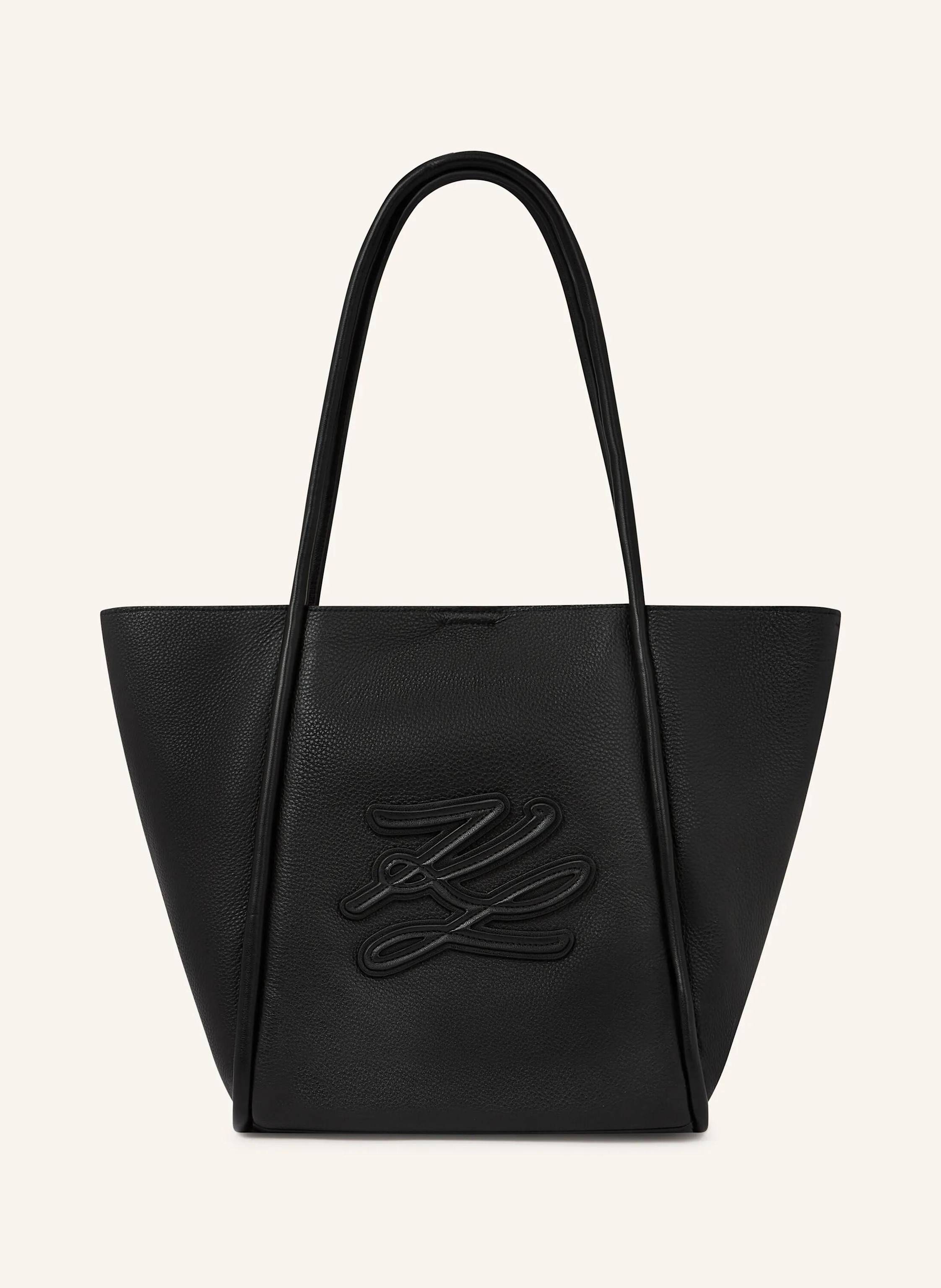 Karl Lagerfeld This medium tote bag blends a spacious, laptop-friendly silhouette with elongated twin handles for effortless carrying. The tonal Karl Autograph logo adds a refined, modern touch. Perfect from office in schwarz