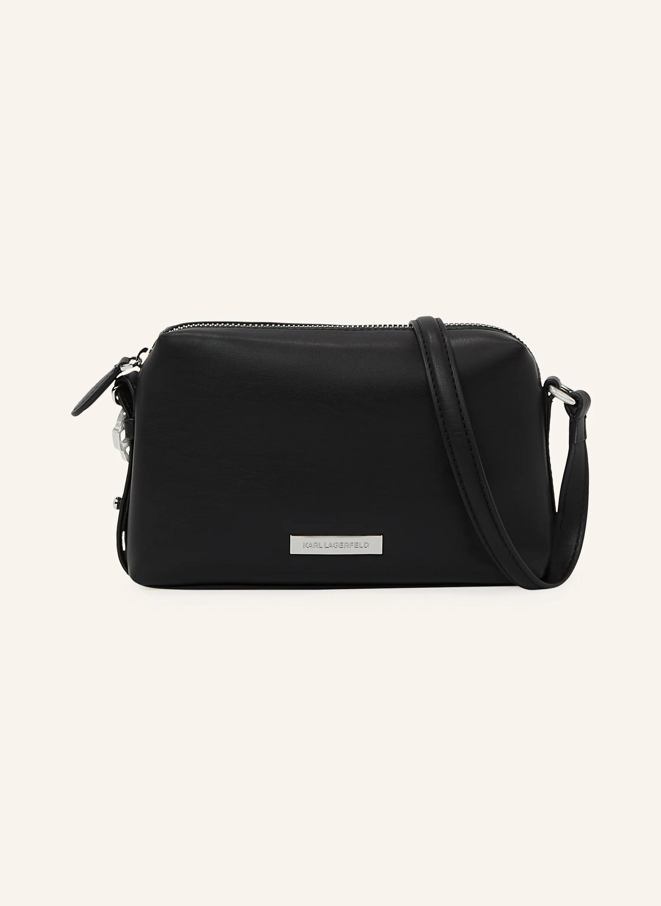 Karl Lagerfeld A woven crossbody bag with a zip-top closure that secures your essentials. Adjustable strap offers versatile styling, while metal Ikon charm and KARL LAGERFELD plaque add bold, modern detail. Zip-top in schwarz