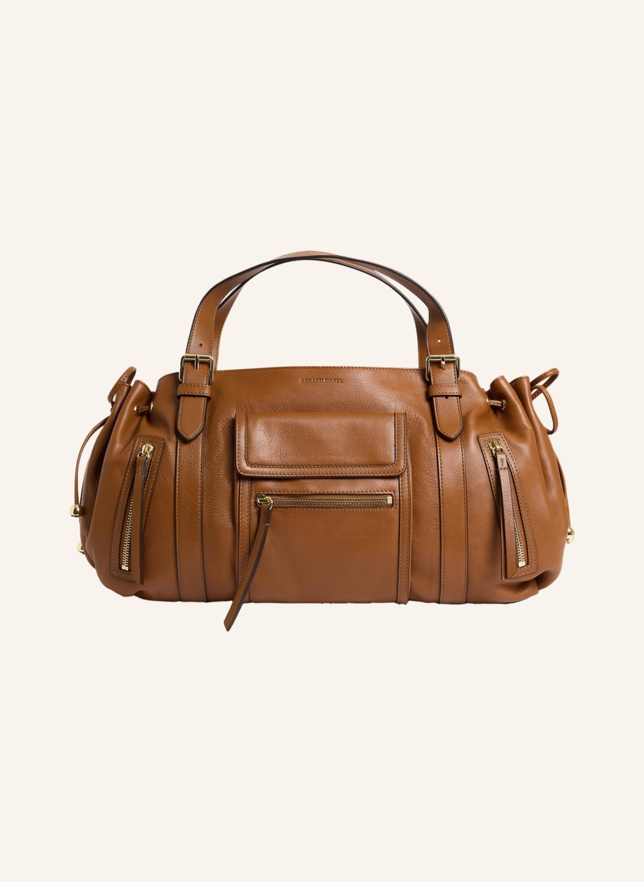 Gerard Darel ST GERMAIN ist das Kultmodell 24 H im schicken Rock?n?Roll-Stil. Praktisch in der Stadt dank zahlreicher Außentaschen mit Reißverschluss und verstellbarer Griffe ? der ideale Begleiter für aktive Stad in cognac