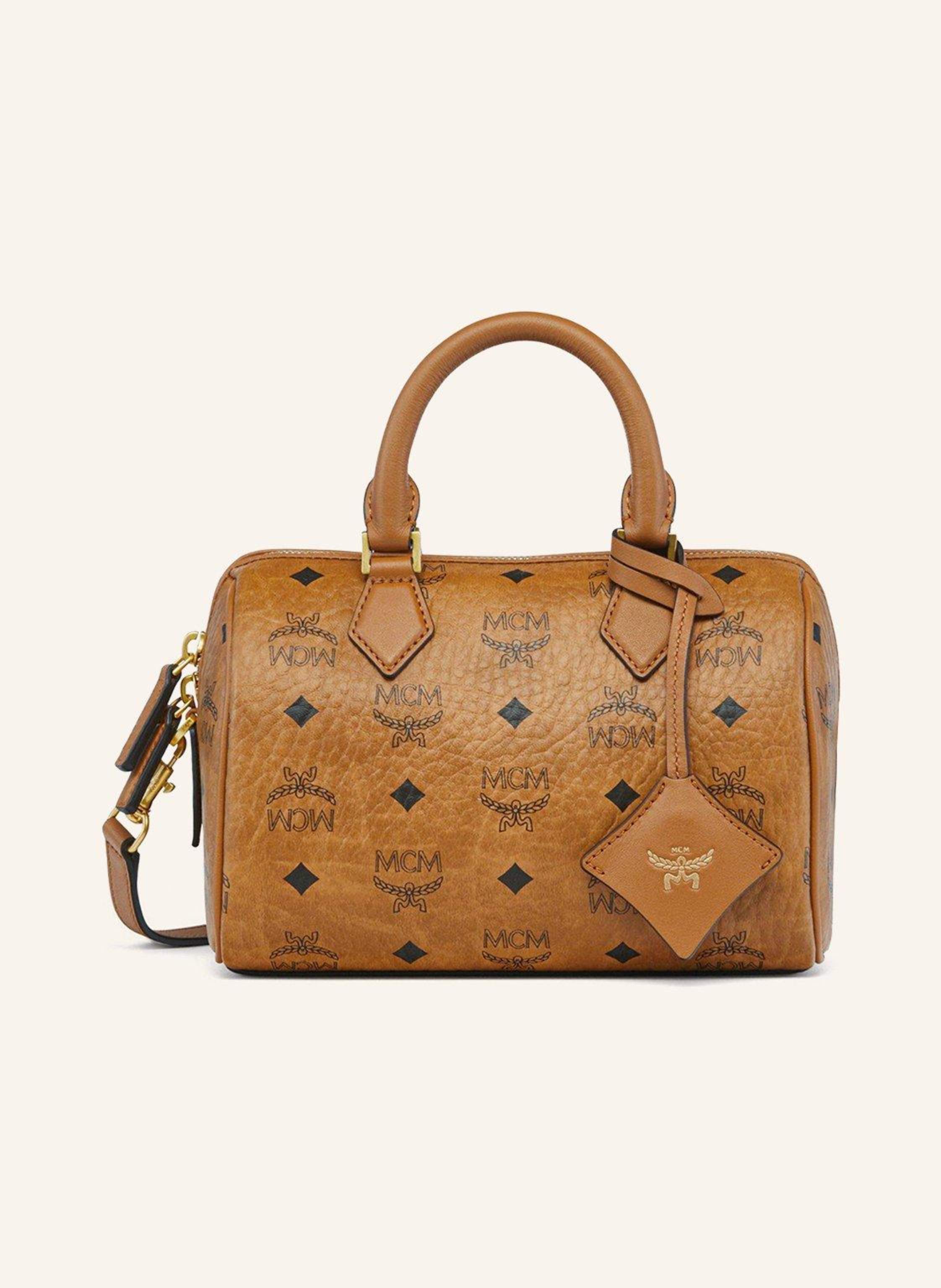MCM Ein Steckfach. Abnehmbarer Schulterriemen. Längenverstellbarer Schulterriemen. Zwei Tragegriffe. Verstärkter Taschenboden. Reißverschluss. Innen ein Hauptfach. Beschichtetes Canvas. Monogramm-Muster in cognac