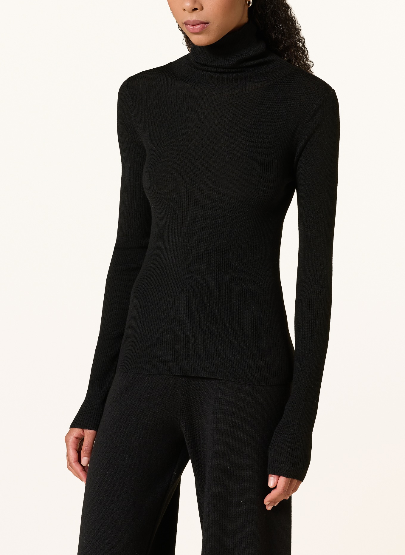 Rhea. Turtleneck sweater: BLACK